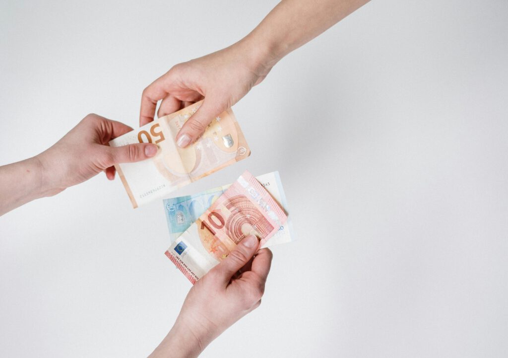 Person holding 10 and 10 euro banknotes